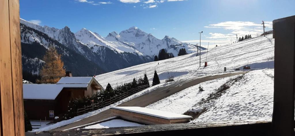 a snow covered slope with a mountain in the background at Combe Blanche 1217 in Manigod