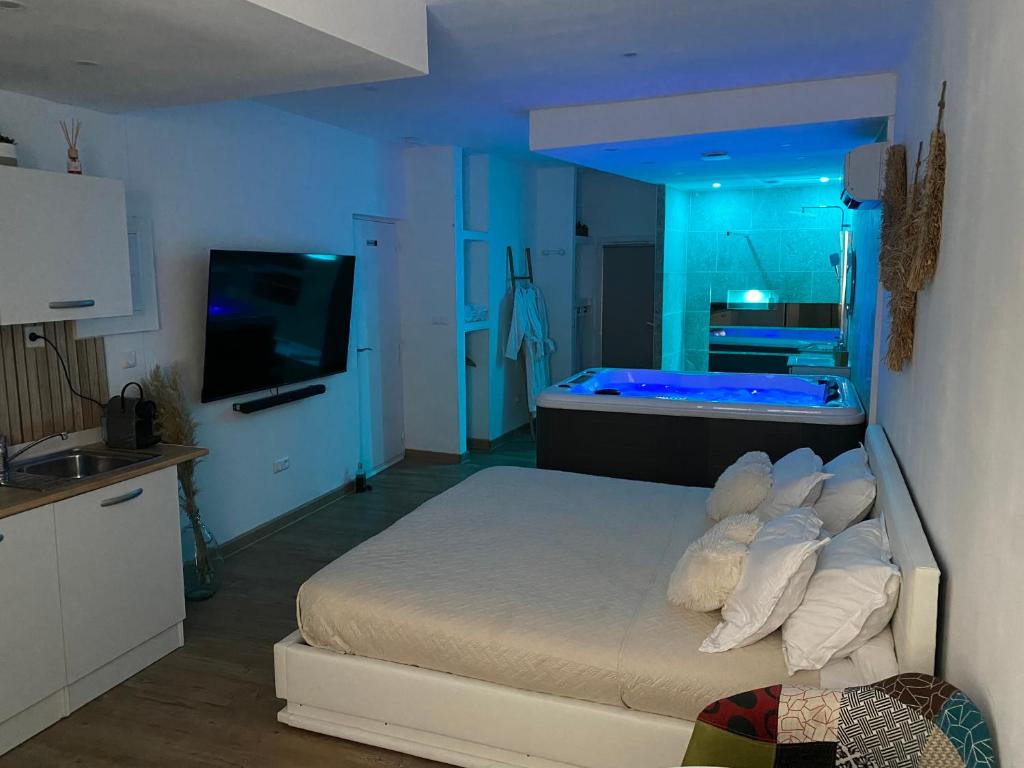 a bedroom with a bed and a bathroom with a tub at Superbe suite avec jacuzzi patio et sauna in La Ciotat