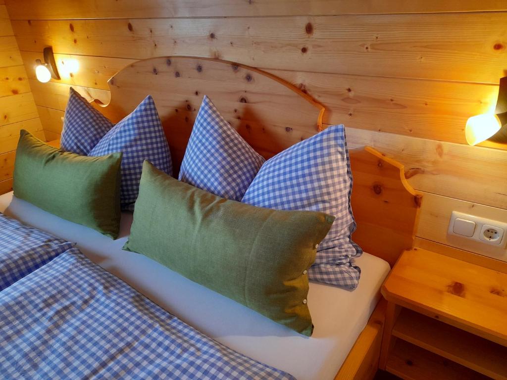 a bedroom with a bed with blue and green pillows at Haus Schwaiger in Bad Hofgastein