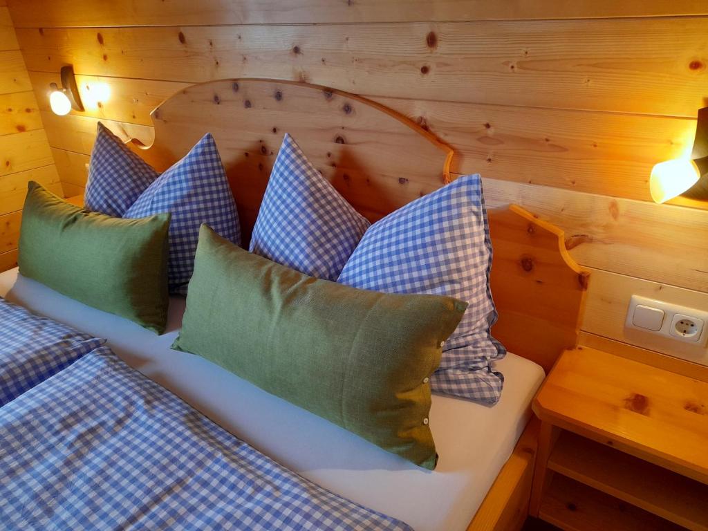 Schlafzimmer mit einem Bett mit blauen und grünen Kissen in der Unterkunft Haus Schwaiger in Bad Hofgastein