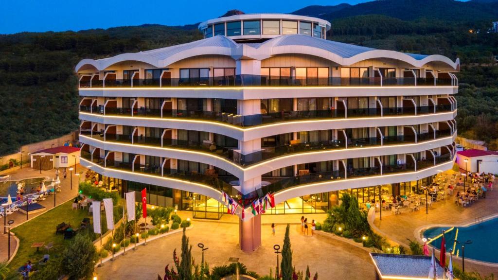 ein Bild eines Gebäudes mit Leuten, die um ihn herum laufen in der Unterkunft Seven For Life Thermal Hotel in Kusadası