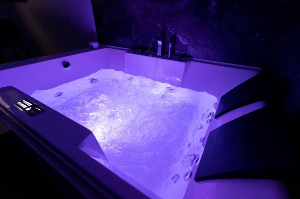 una vasca da bagno con luce viola in camera di B&B Chiaro di Luna a Barletta