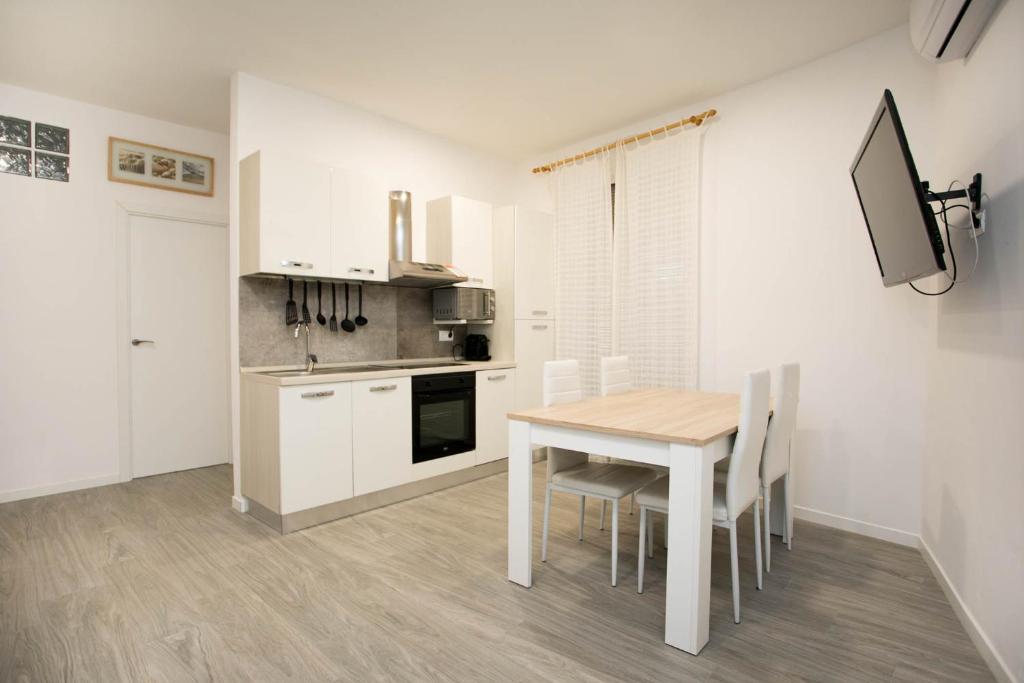 una cocina blanca con mesa y sillas. en Apartament al cor de Begur, en Begur