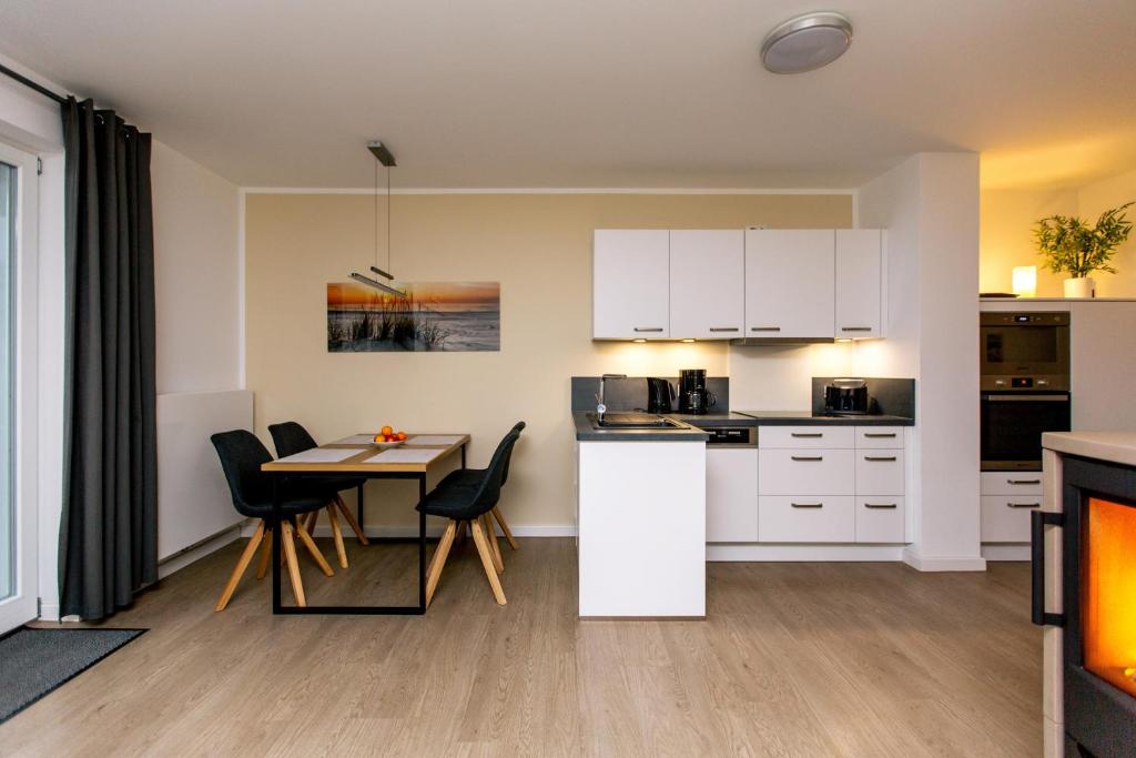 een keuken en eetkamer met een tafel en stoelen bij Hafendorf Haus 7_ Apartment 4 in Plau am See