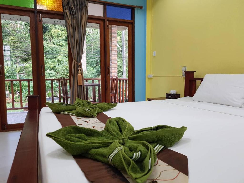 a bedroom with a bed with green towels on it at Coconut corner in Ko Yao Noi