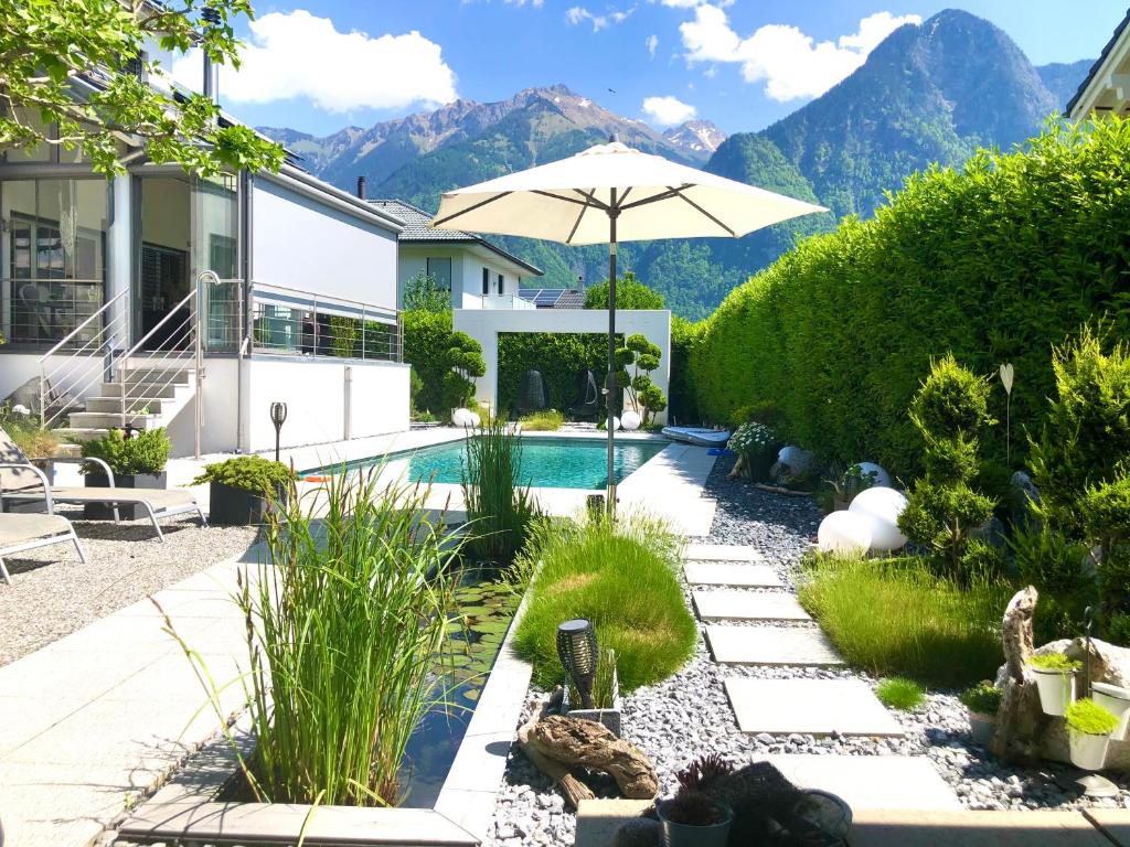 a backyard with a swimming pool and an umbrella at Sunny Way Home Accommodation & Spa in Weite
