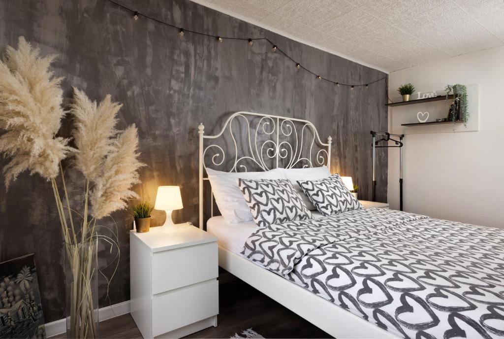 ein Schlafzimmer mit einem schwarzen und weißen Bett und einer Wand in der Unterkunft Apartment Viksa with Jacuzzi in Zagreb
