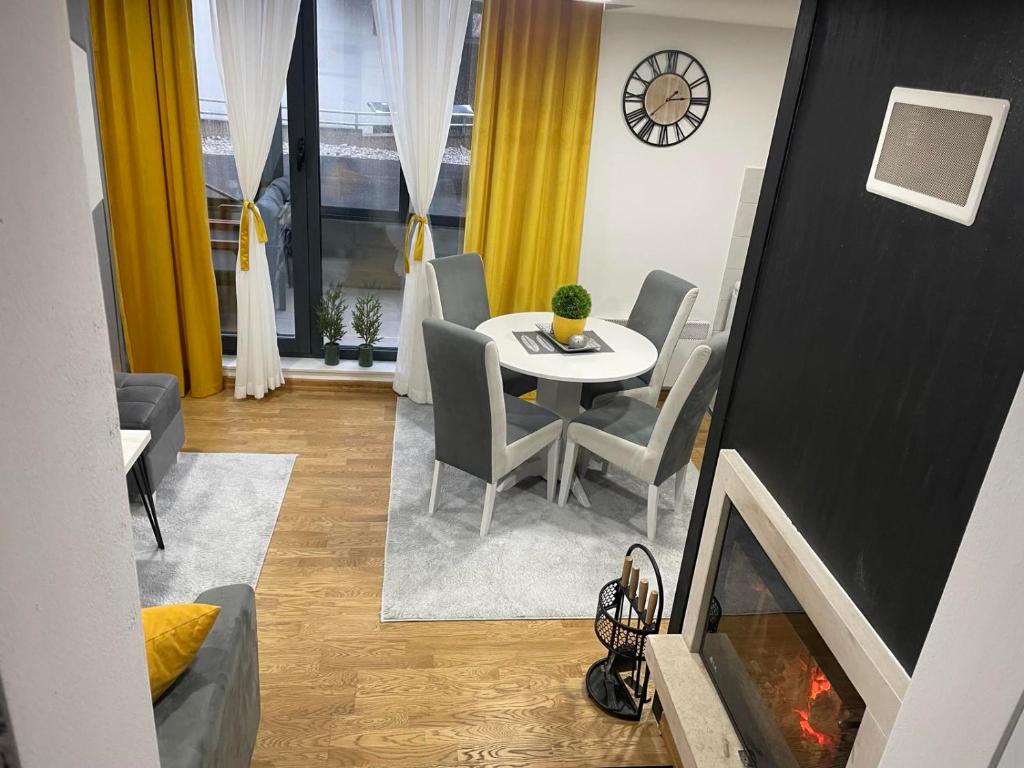 別拉什尼察的住宿－White Mountain Bjelašnica，客厅配有桌椅和壁炉