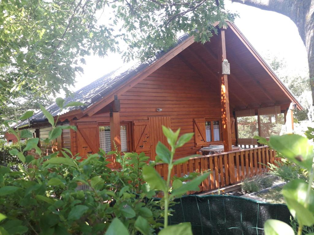 uma cabana de madeira com um alpendre e um deque em PRL Le Védrignans - PRL El Pastural em Saillagouse