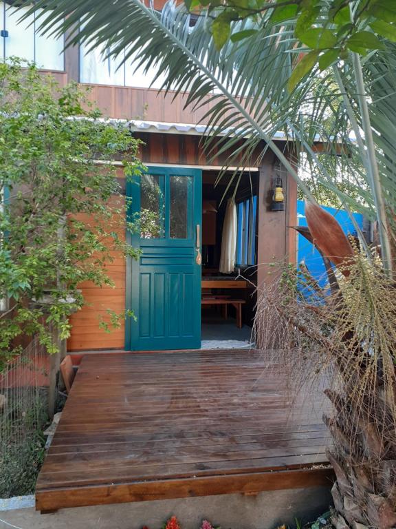 Casa con puerta azul y terraza de madera en Jabuticasa Cabana de madeira na praia, en Penha