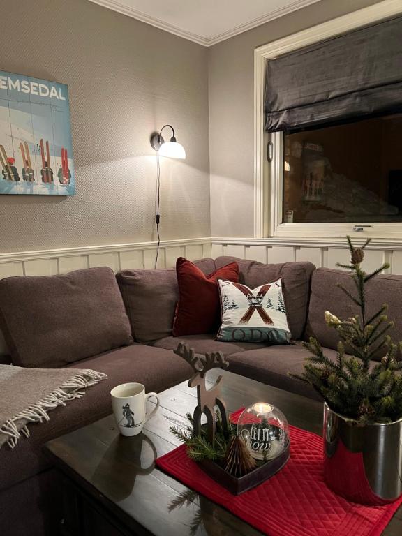 a living room with a couch and a christmas tree on a table at Hyggelig leilighet i sentrum in Hemsedal