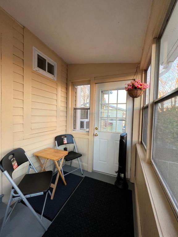 une petite chambre avec des chaises, une table et une porte dans l'établissement Pacifico's Place "B", à Hartford