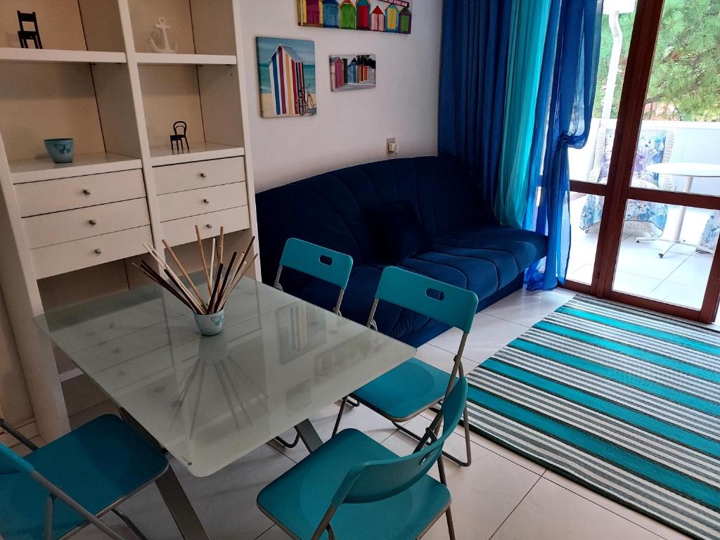 un soggiorno con tavolo e sedie in vetro di SOLARE a Bibione