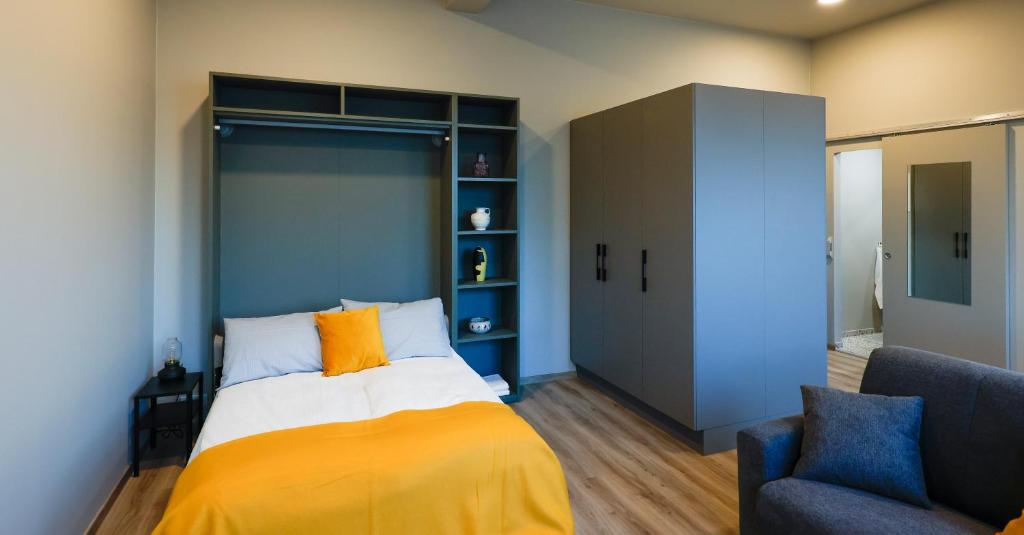 een slaapkamer met een bed, een bank en een stoel bij Center Apartments - Esja in Reykjavík