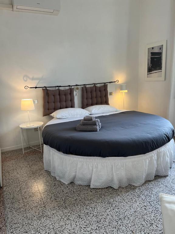 a large bed in a bedroom with two lamps and a bedvisor at B&B Cristina e Stefano in Pisa