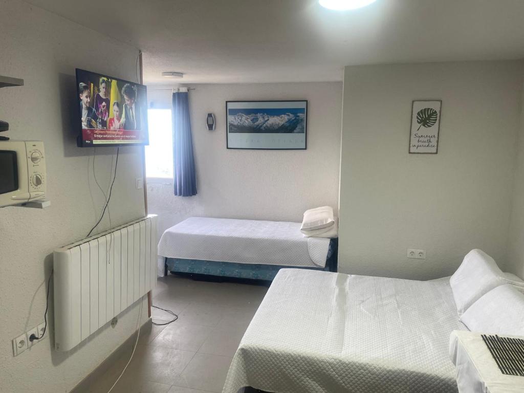Habitación de hotel con 2 camas y TV en Bonito apartamento vistas espectaculares, en Granada