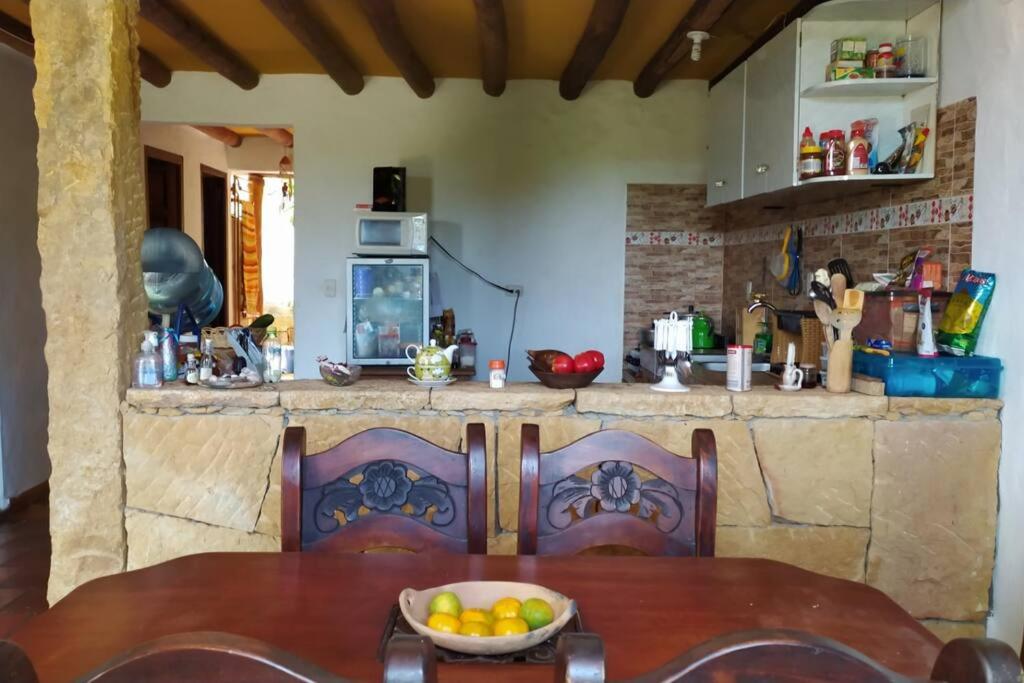 una cocina con una mesa con un bol de fruta. en Casa Bari Bari en Barichara