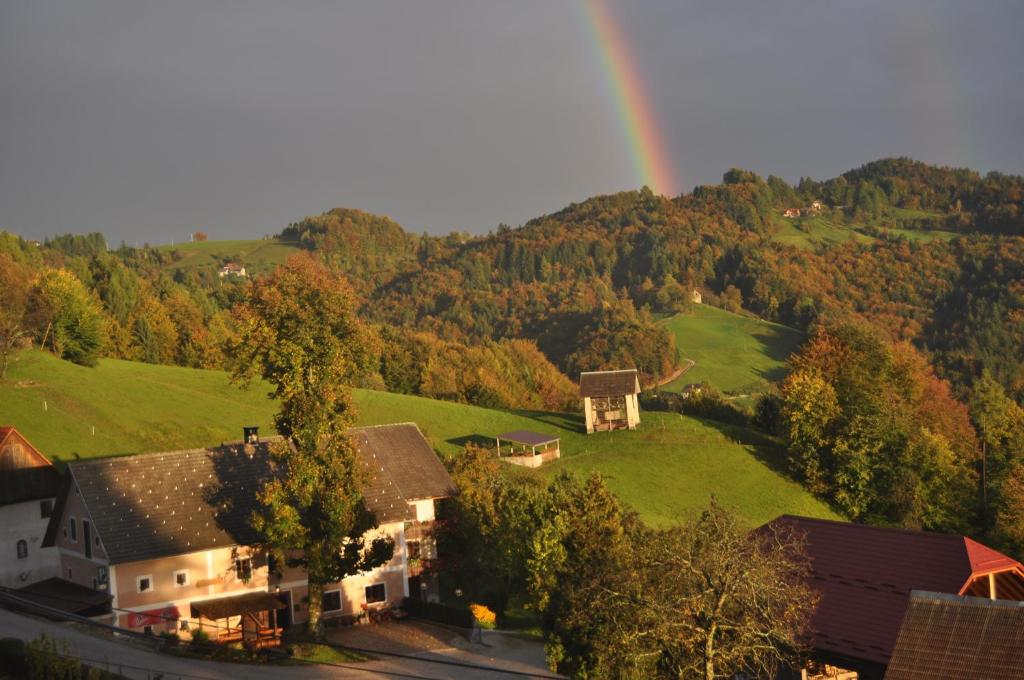 une vue aérienne sur une maison avec un arc-en-ciel en arrière-plan dans l'établissement Apartments Lovec, à Cerkno