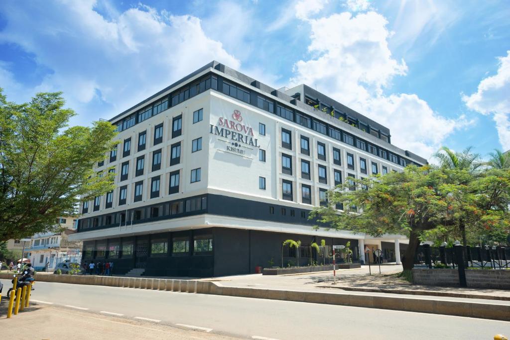 - un grand bâtiment blanc avec un panneau dans l'établissement Sarova Imperial Hotel, à Kisumu