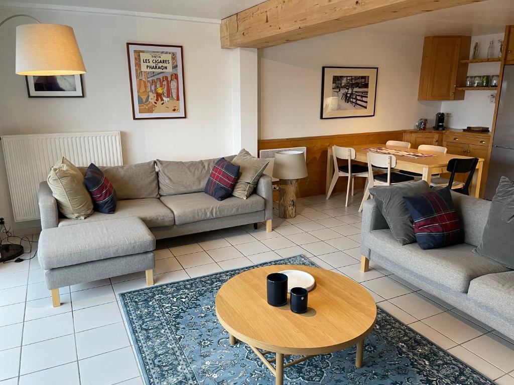 a living room with two couches and a table at Central Morzine, Spacious 2 Bedroom Family Apartment in Morzine