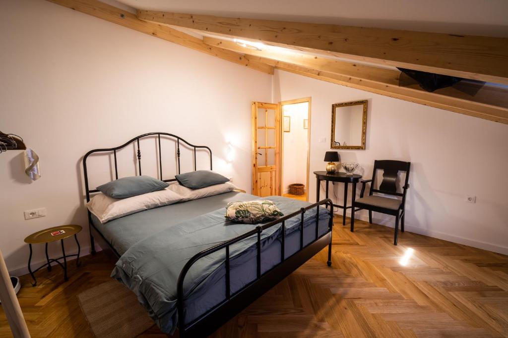 een slaapkamer met een bed, een tafel en een stoel bij Guesthouse Riba in Vrsar