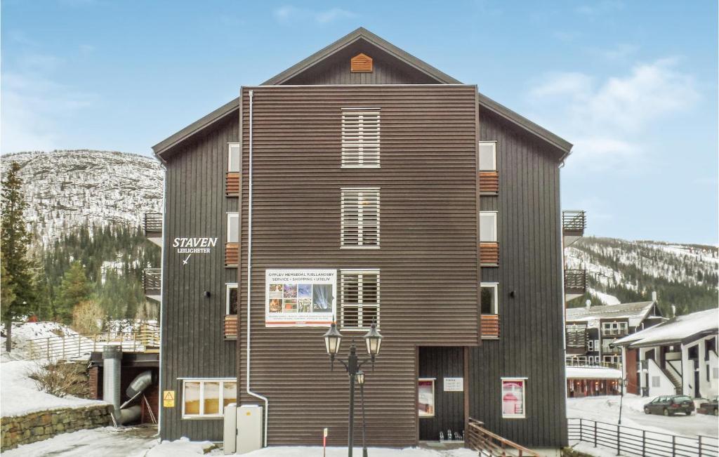 a building in the snow in front of a mountain at Nice Apartment In Hemsedal With 2 Bedrooms, Sauna And Wifi in Hemsedal