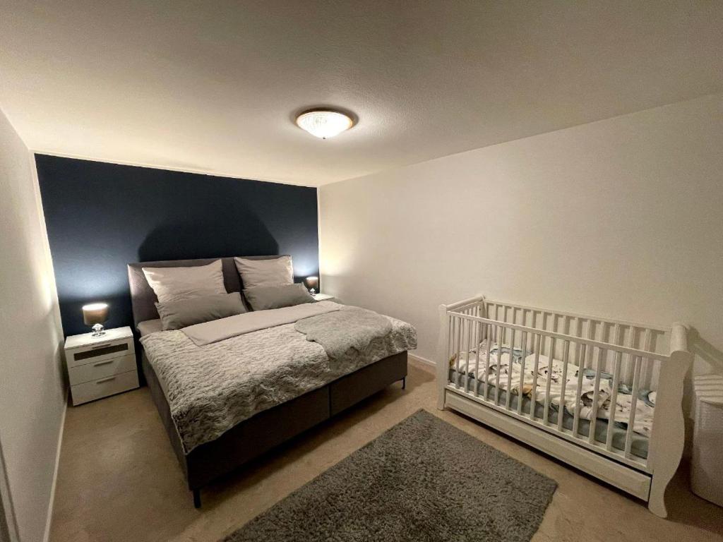 a bedroom with a bed and a baby crib at Feriendomizil zwischen Badeb-Baden - Offenburg in Ottenhöfen