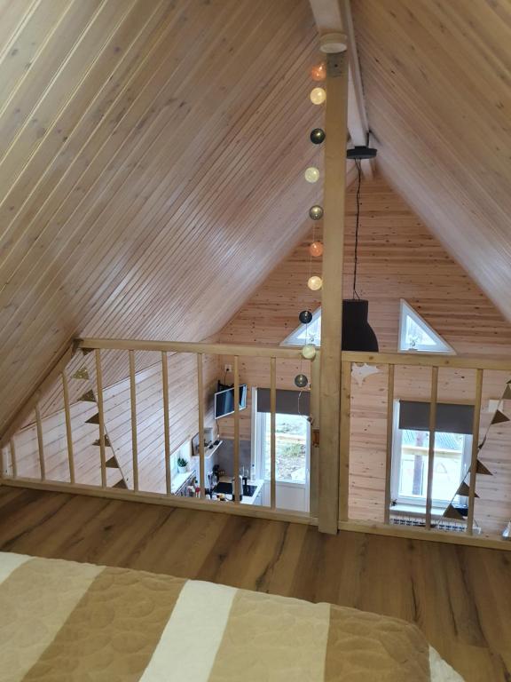 ホーラズにあるStuga i Storklintenの木製の天井と窓が特徴の屋根裏部屋