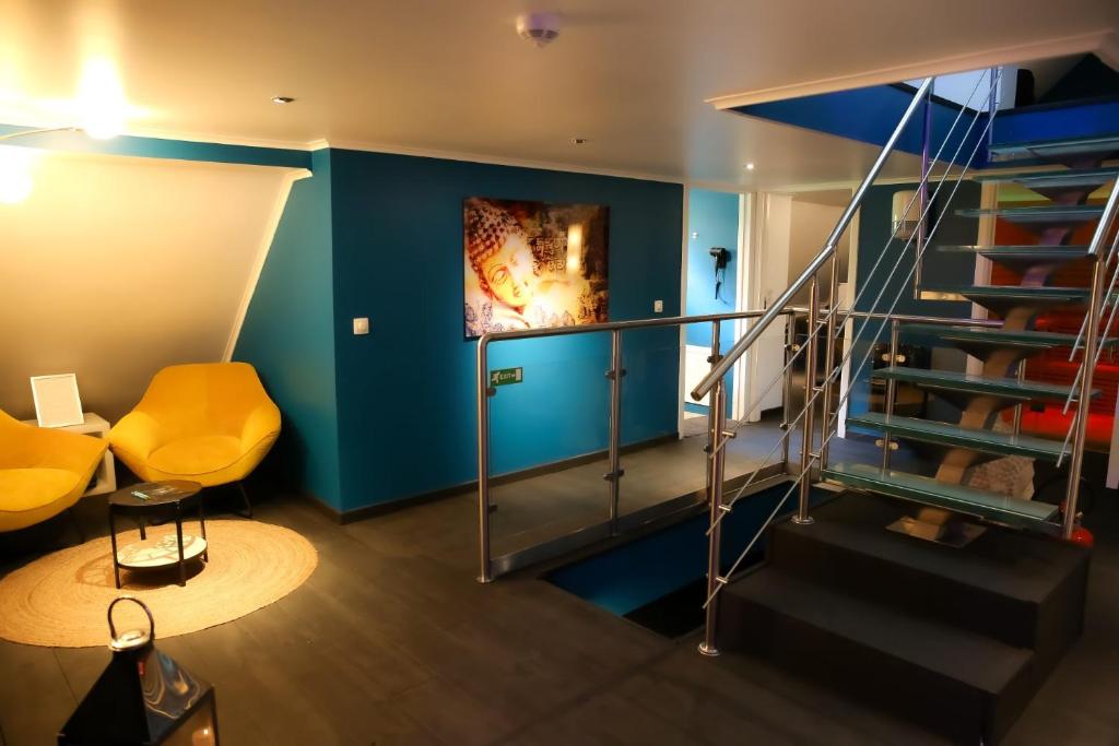 a room with a staircase and a blue wall at Le Wellness Privatif in Seraing