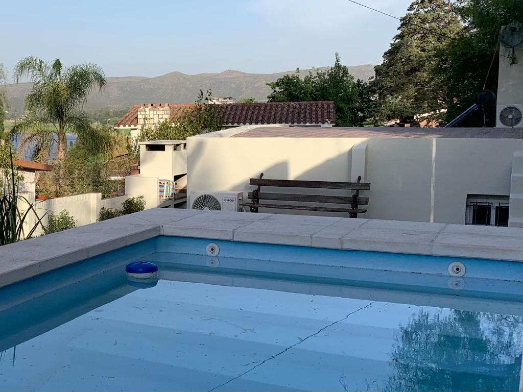 a swimming pool with a bench next to a table at Casa de Ali in Villa Carlos Paz