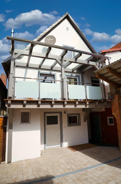 a white house with a balcony on top of it at Ferienwohnung Ulla in Bad Staffelstein