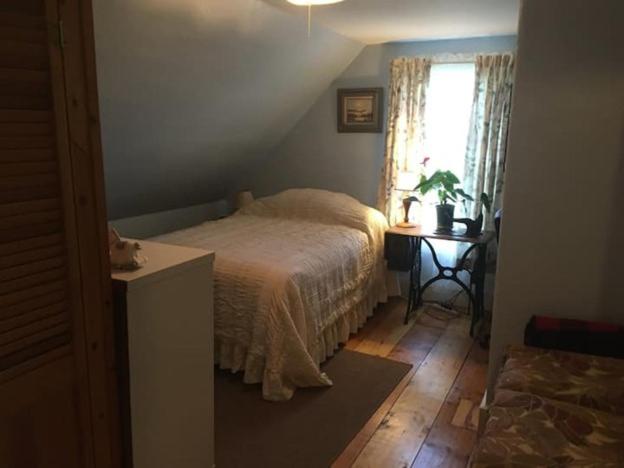 a bedroom with a bed and a table and a window at Labyrinthia Guest House in Dexter