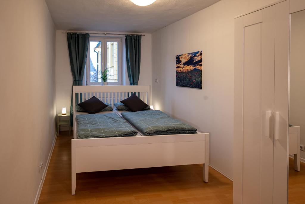 a small bedroom with a white bed with a window at Ferienwohnung Ulla in Bad Staffelstein