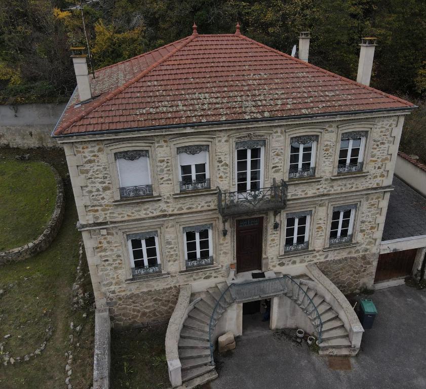 una vecchia casa con una scala di fronte di Grande maison bourgeoise a Malleval