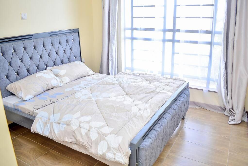 Un pat sau paturi într-o cameră la Rhezoh Apartment