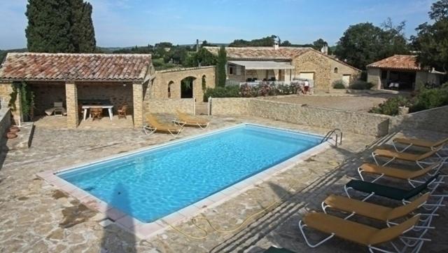 une grande piscine avec des chaises et une maison dans l'établissement LE MAS PROVENCAL, à Vaison-la-Romaine