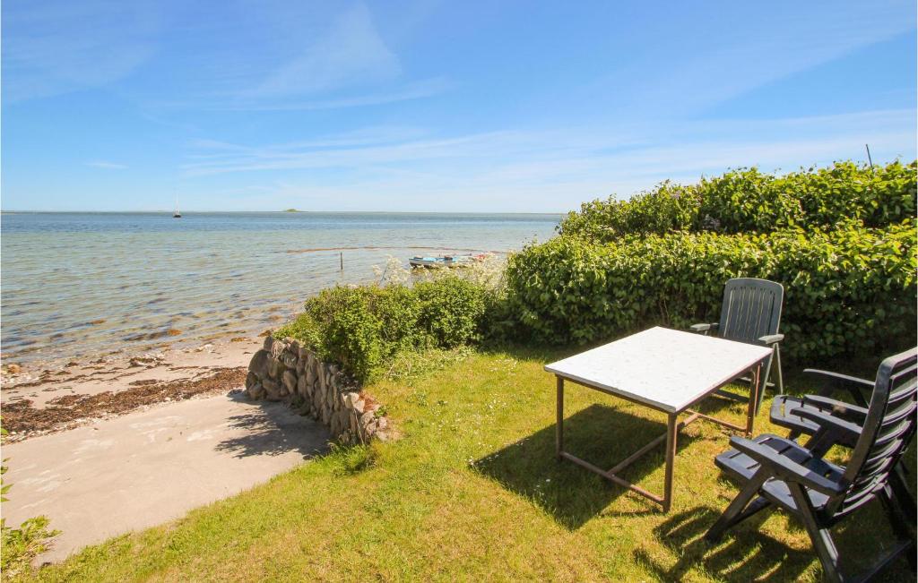 a table and two chairs sitting next to the beach at Nice Home In Sams With 2 Bedrooms And Wifi in Toftebjerg