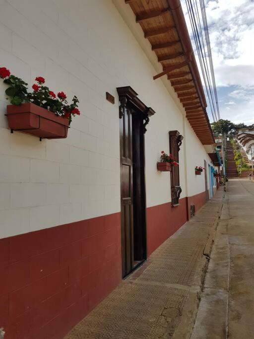 un bâtiment avec des boîtes de fleurs sur son côté dans l'établissement Casa Bethlen, à Zapatoca