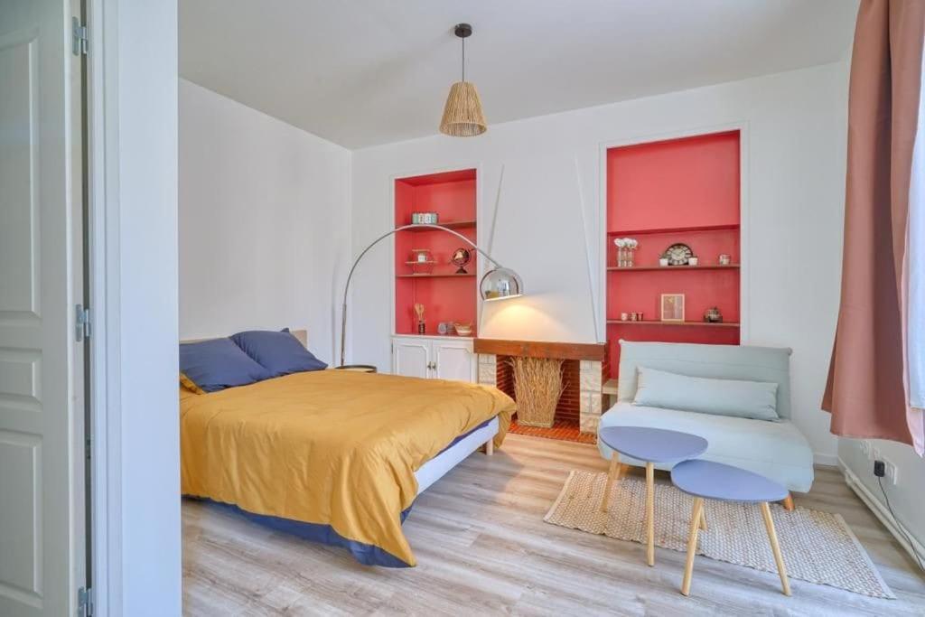 een slaapkamer met een bed, een stoel en rode kasten bij studio cosy hypercentre proche Paris in Corbeil-Essonnes