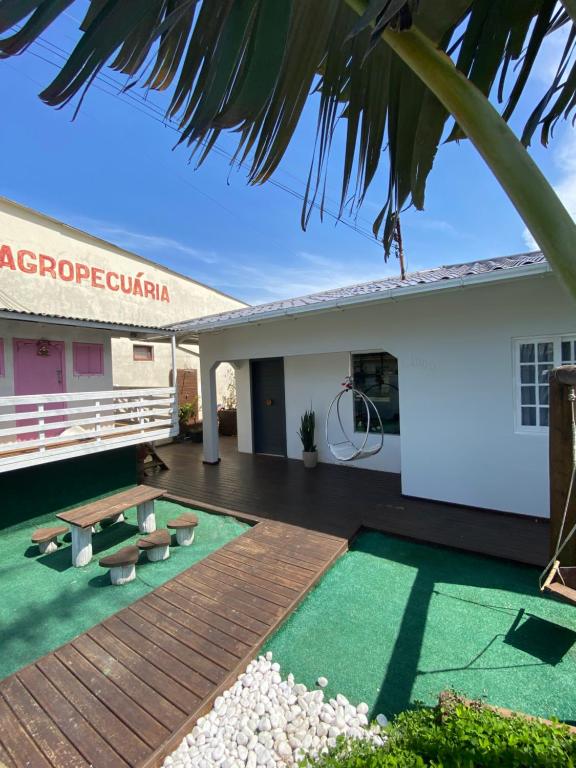 een gebouw met een houten terras met groen gras bij Casa conchas das Caravelas in Governador Celso Ramos