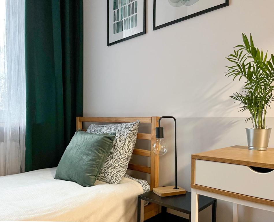 a bedroom with a bed with a green curtain at Shape&Color premium Hostel in Warsaw