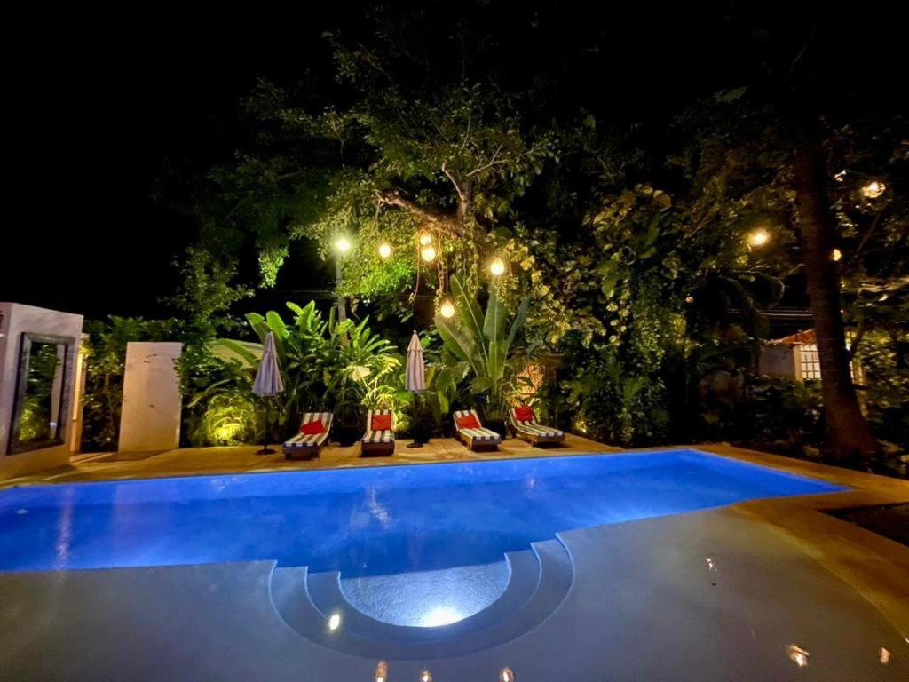 een zwembad met stoelen en verlichting bij VIA TENDENZA VILLAS in Playa del Carmen
