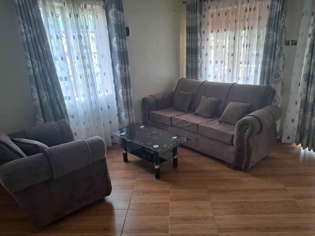 a living room with two couches and a coffee table at Gorilla Backpackers Lodge Kabale in Kabale