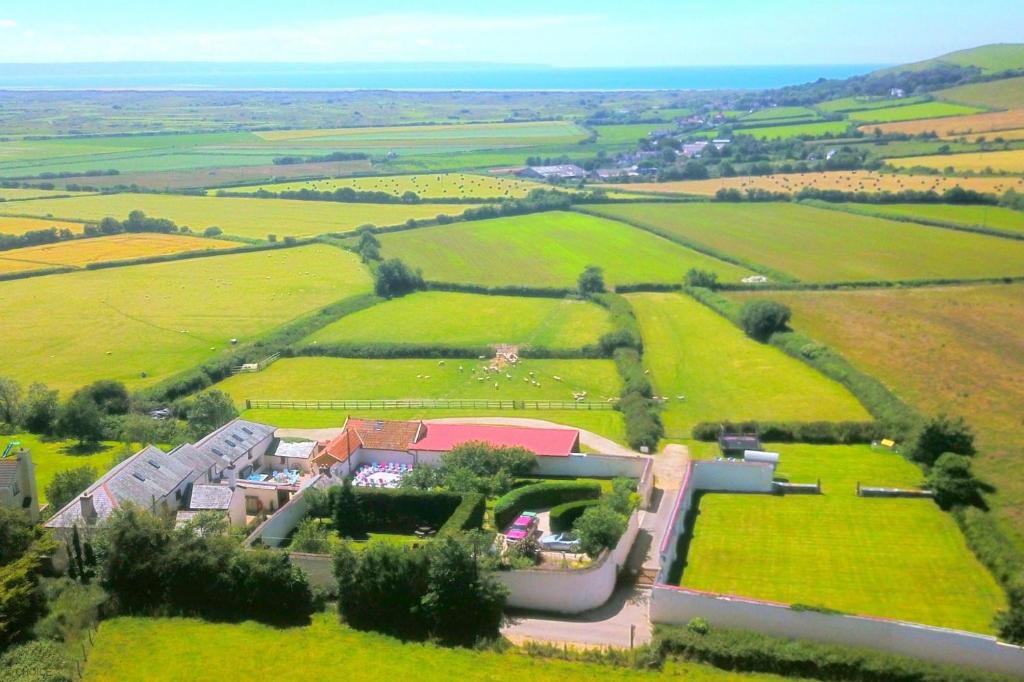 une vue aérienne d'une maison au milieu d'un champ dans l'établissement SAUNTON GRANGE 7 Bedrooms, à Braunton