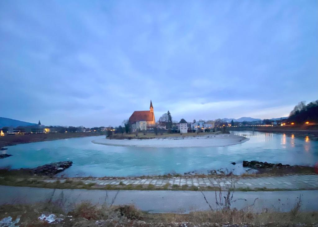 ラウフェンにあるFerienwohnung an der idyllischen Salzachschleife Nähe Salzburgの遠方の教会のある川の景色