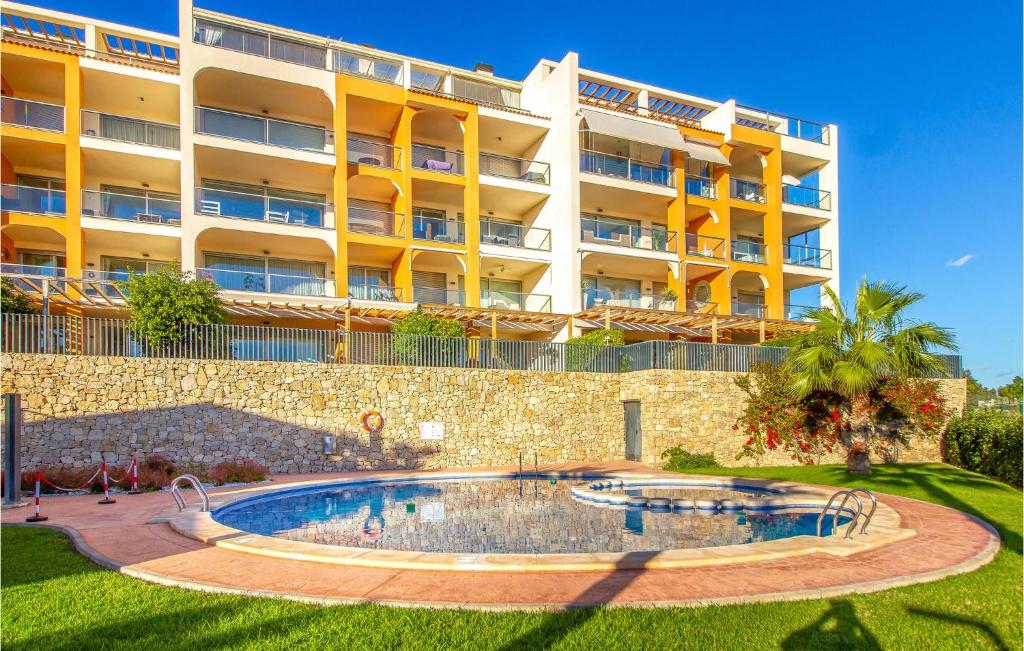 ein großes Gebäude mit einem Swimmingpool davor in der Unterkunft 3 Bedroom Cozy Apartment In Villajoyosa in Villajoyosa
