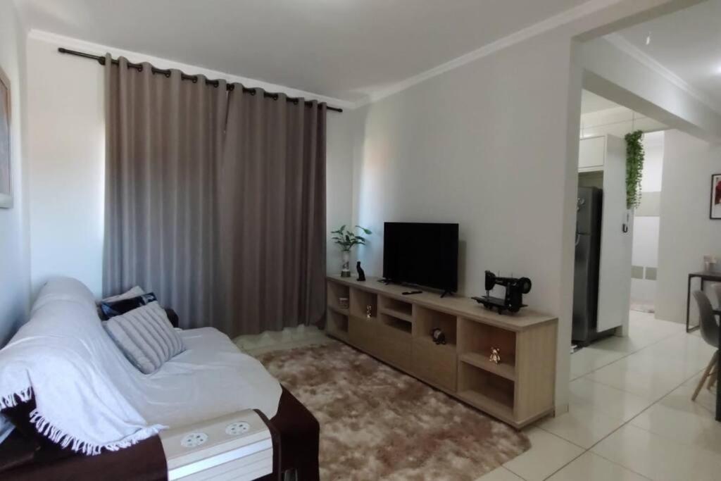 um quarto com uma cama e uma televisão de ecrã plano em Apartamento Doce Aconchego - RESIDENCIAL WAKI 05 em Dourados