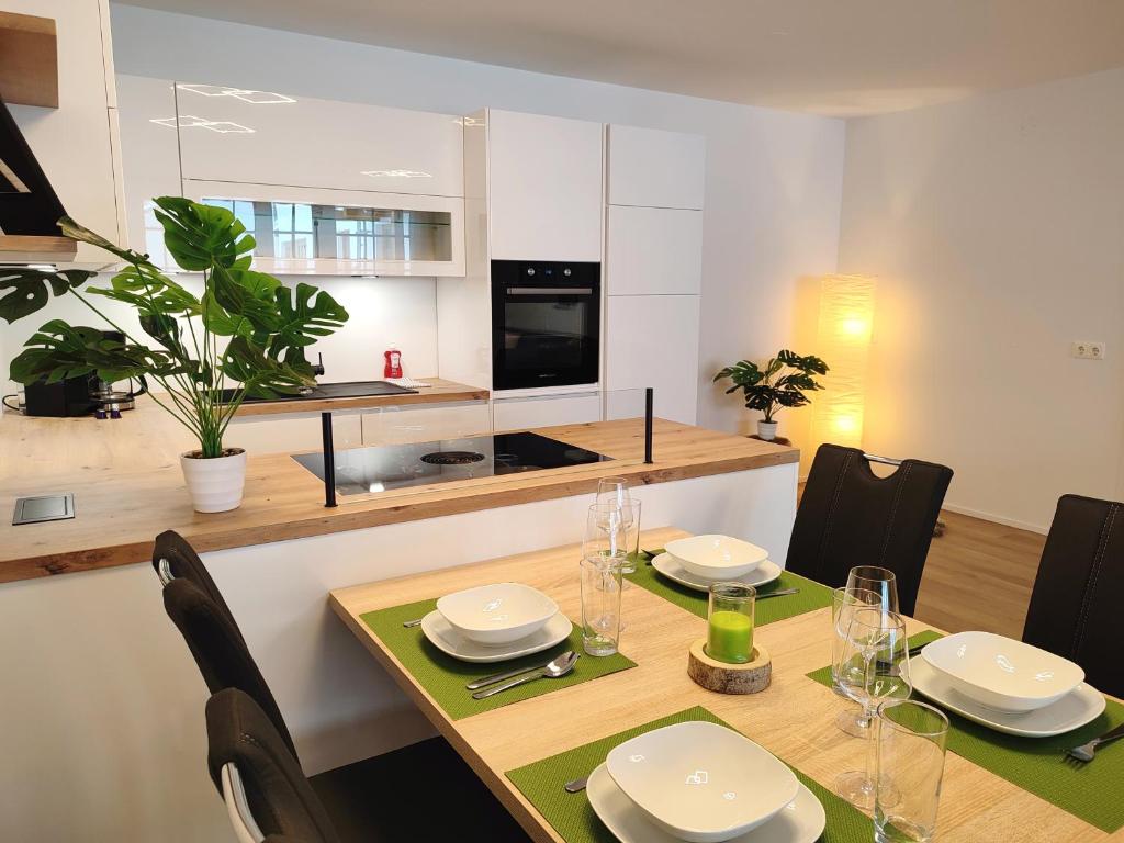 a dining room with a table and a kitchen at Modern Mountain Apartment - free parking & sauna in Obertauern