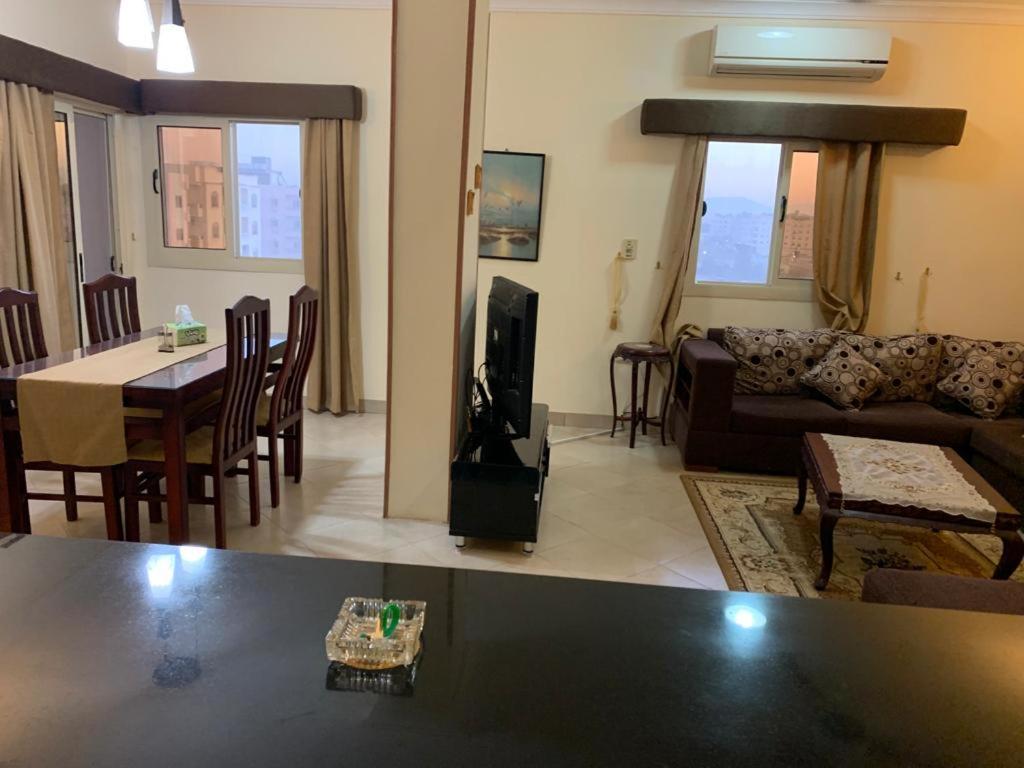 sala de estar con sofá, mesa y TV en شقة سكنية ذات طابع عائلى متميز بها كافة الامكانيات من فلتر ماء وواى فاى, en Hurghada