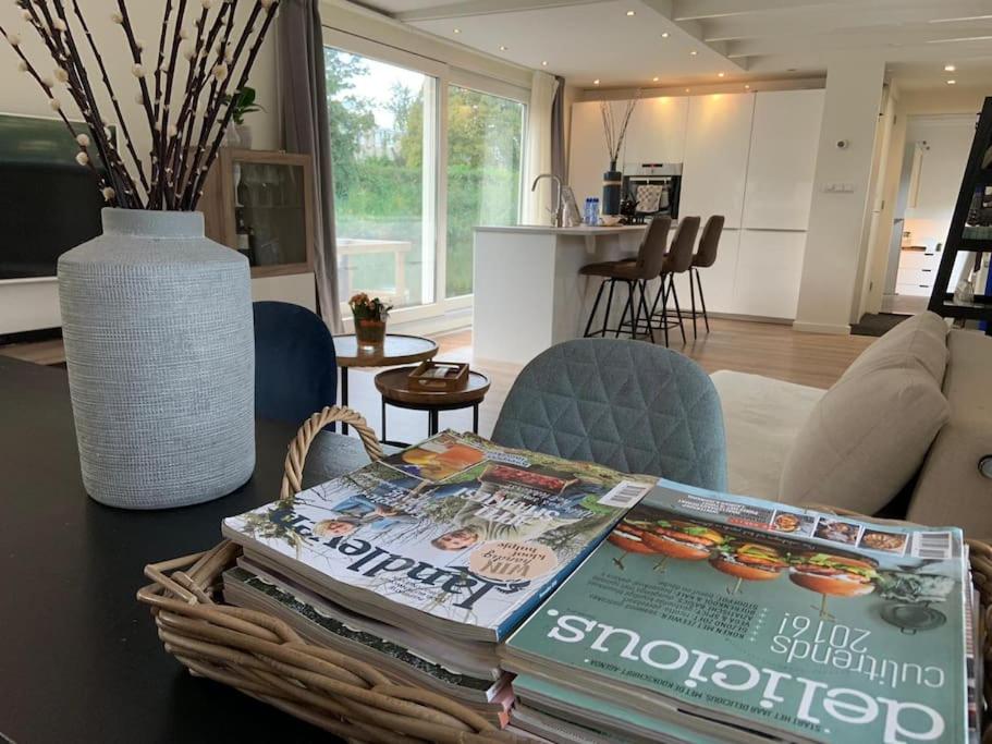una sala de estar con una mesa con una revista. en Quiet Waterloft near Amsterdam and Schiphol WS17 en Aalsmeer